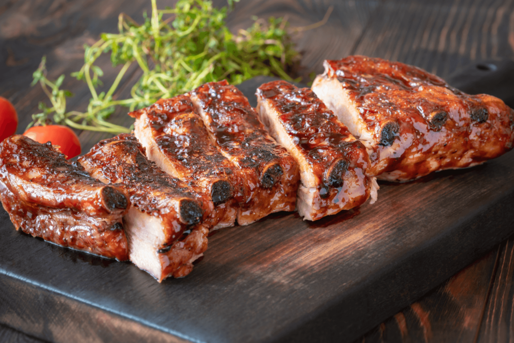 Summer Recipe: Glazed pork back ribs sliced on a wooden cutting board.