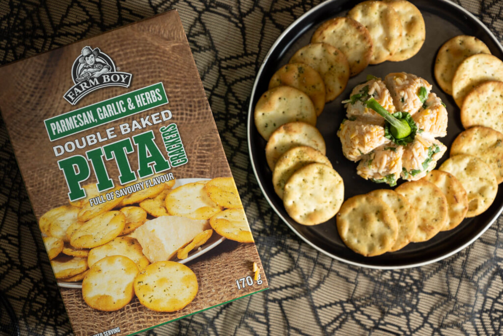 Overhead image of plate with Farm Boy Double Baked Pita Crackers and a pumpkin-shaped cheese ball.