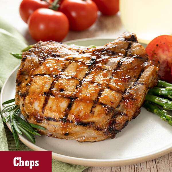 Easy to prepare grilled Pork Chops on a plate served with roasted asparagus.