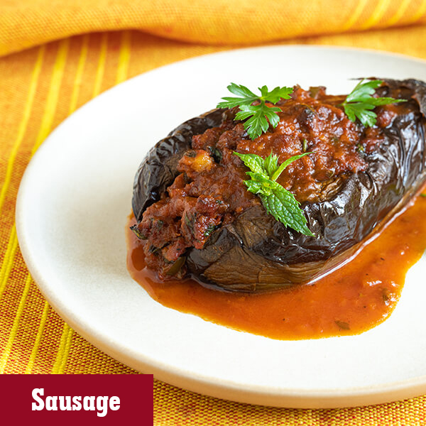 Easy to prepare Savoury Stuffed sausage Eggplants served on a plate with garnish. 