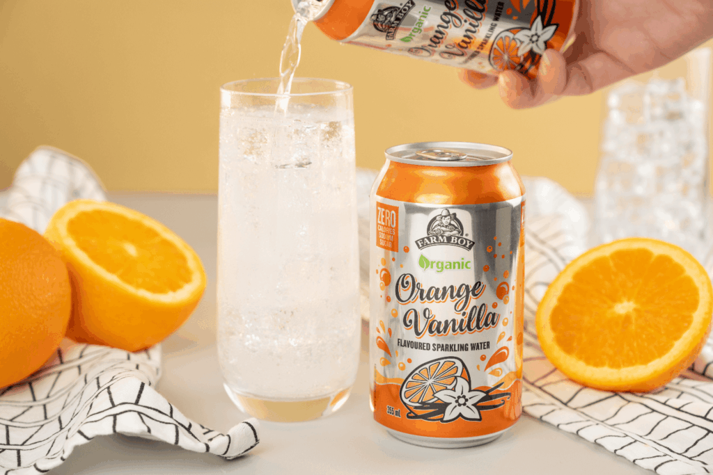 Can of Farm Boy Organic Orange Vanilla Sparkling Water poured into glass