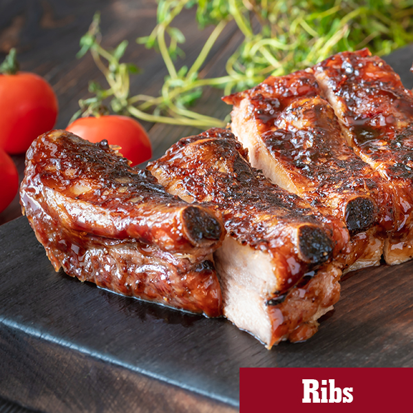A wooden board with BBQ Glazed pork back ribs. They look shiny and delicious. Pork ribs are the main ingredient for this hero image.