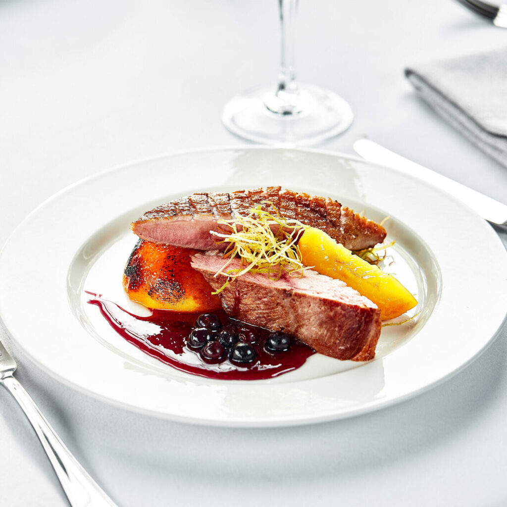 Grilled Duck Breast with Berry Sauce and Peaches.