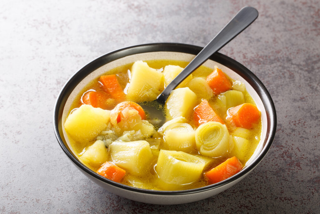 Homemade vegetable soup made from leek, potatoes and carrots close-up in a bowl. horizontal
