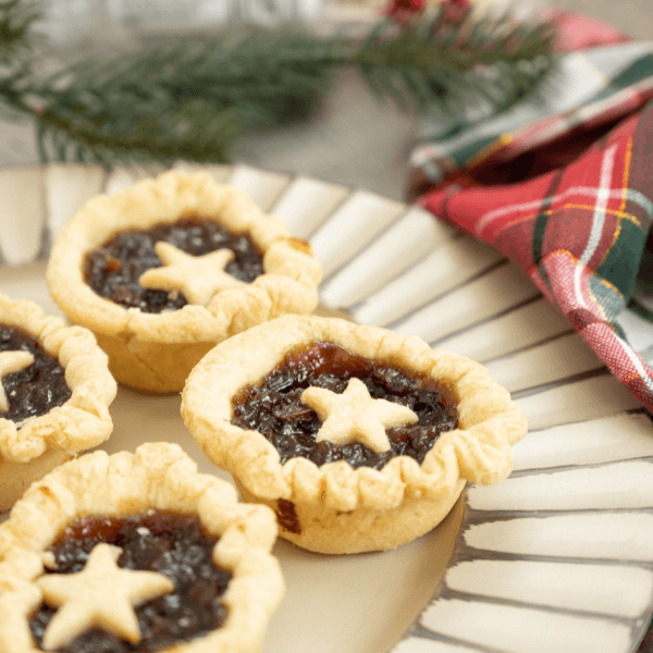 Mincemeat tarts on a plate with holiday decor as a food gift.
