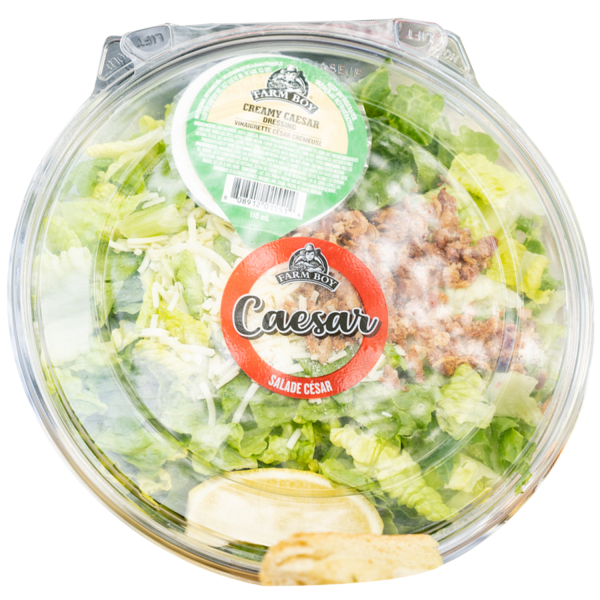 Fresh salad: Farm Boy™ Caesar Salad container. The salad has romain lettuce, bacon, croutons, and a wedge of lemon visible.
