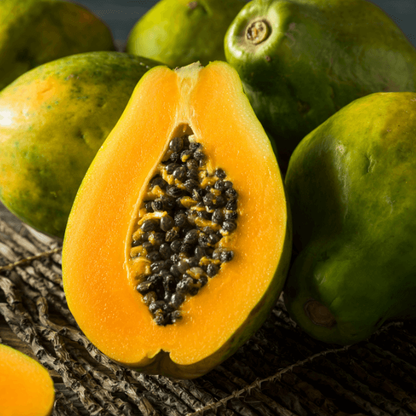 Caribbean fruit: whole and halved papaya with seeds.