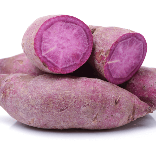 Caribbean vegetable: whole and halved purple sweet potato on white background.