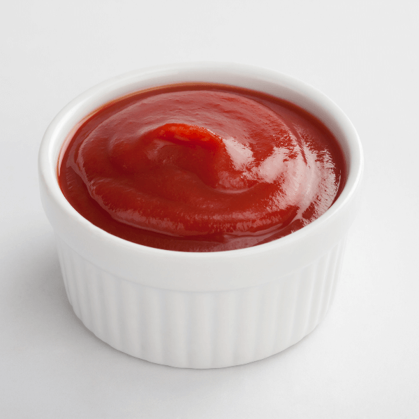 White dip cup filled with ketchup on white background stock photo.