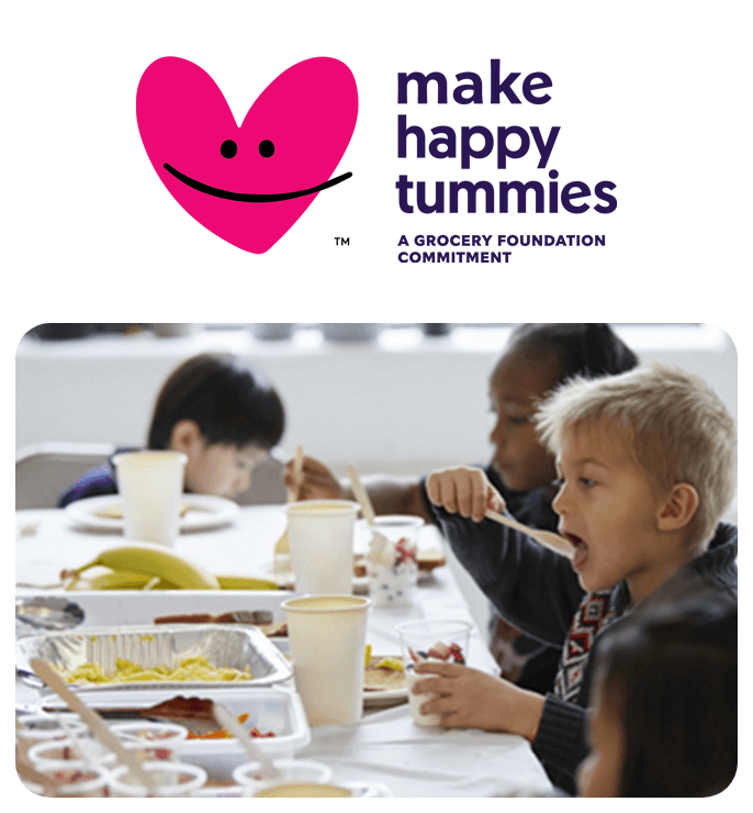 Logo Make Happy Tummies. Image of kids sitting at a table eating their lunch from containers and cups.