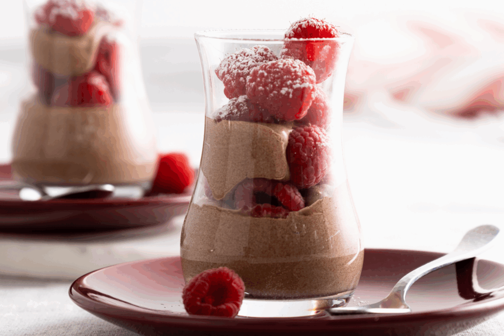 Glass with layers of chocolate mousse and fresh raspberries