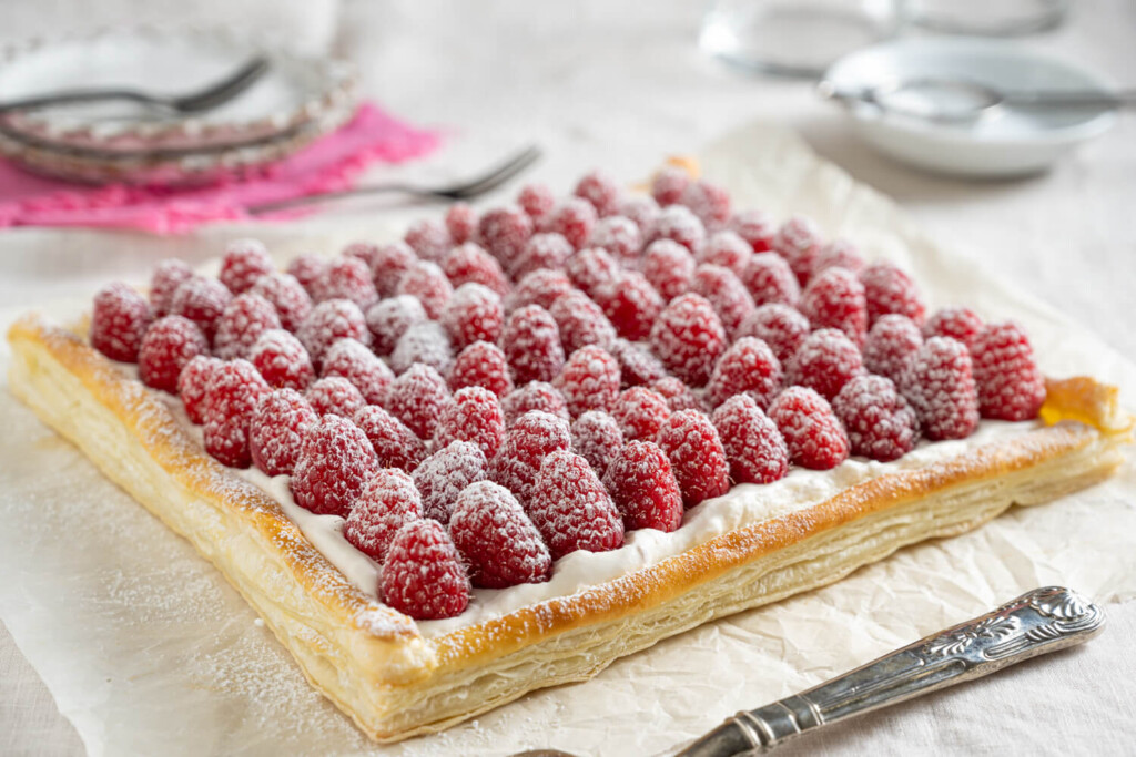 Side view of tart with rows of fresh raspberries