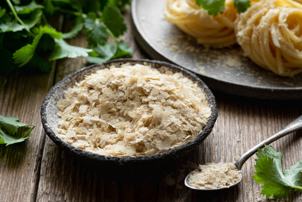Nutritional yeast flakes  on a wooden background , selective focus