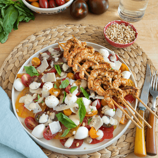 Plate with Caprese salad and shrimp skewers