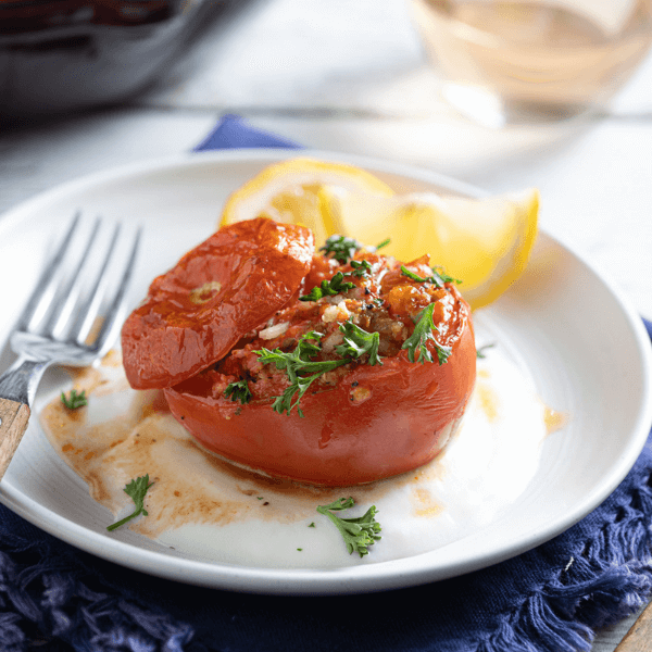 Stuffed tomato on plate with fresh lemon