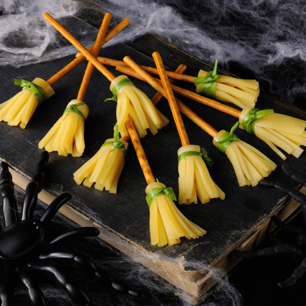 Halloween snack idea of pretzel sticks with cheese wrapped around for witches' brooms