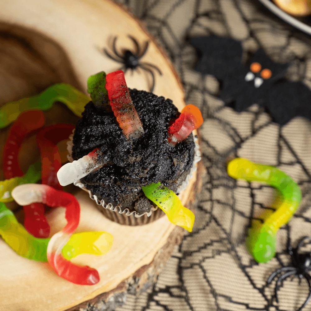 Top view of a chocolate cupcake with gummy worms on it