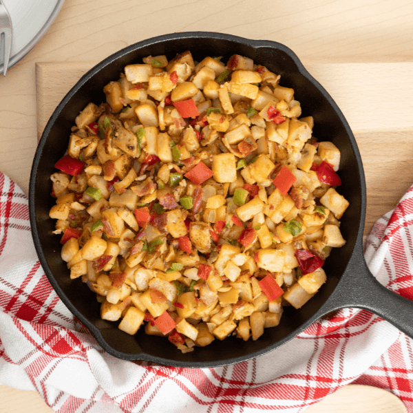 Cast iron pan with smoked bacon hash browns with peppers, onions, and potatoes