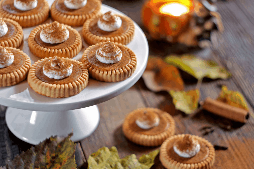 Mini pumpkin pies on a wooden background for harvest sweets table. Selective focus.