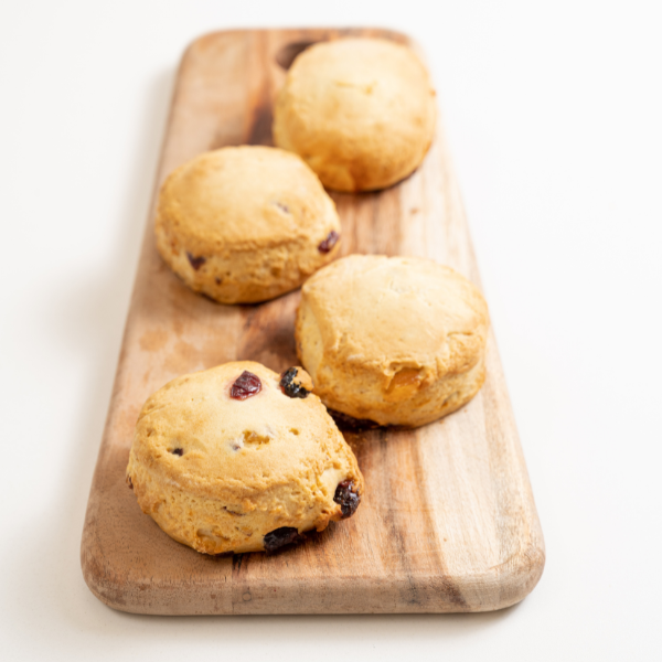 Wooden serving tray with four orange cranberry scones
