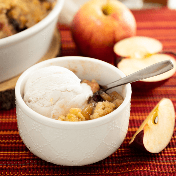 Bowl of Almond Apple Cranberry Crumble with scoop of vanilla ice cream