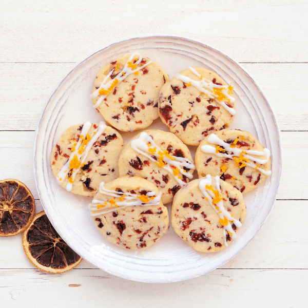 Christmas holiday cranberry orange icebox cookies. Top view table scene on a white wood background.