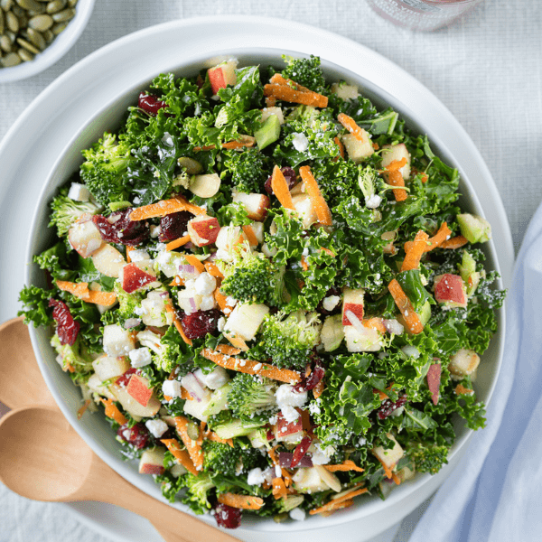 Overhead image of Kale and Broccoli salad with fresh apples, grated carrots, and dried cranberries