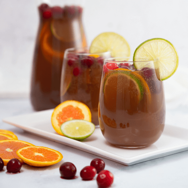 Two glasses of Pomegranate Fruit Punch garnished with lime wheels