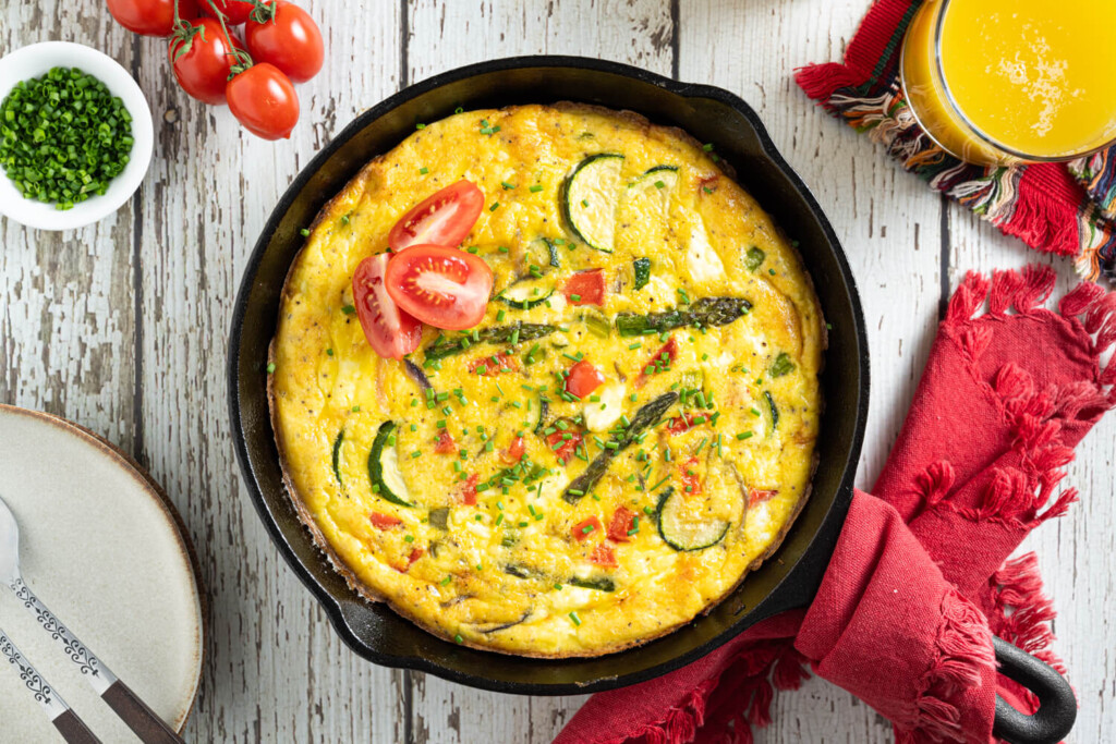 Cast iron pan with asparagus. zucchini, and bell pepper frittata as a healthy brunch recipe