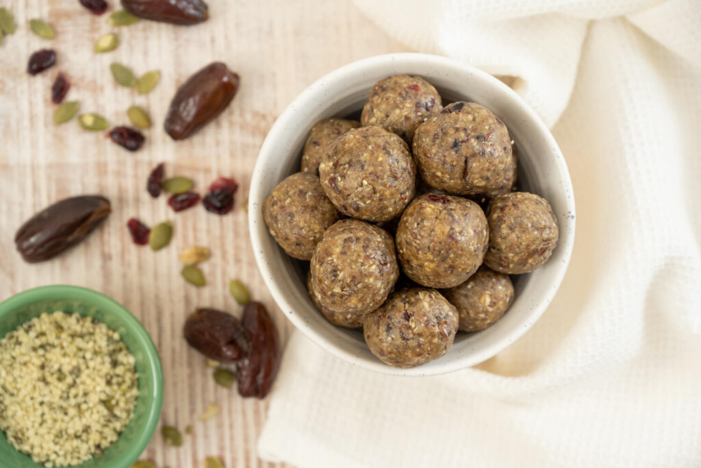 Small white bowl of superseed sunflower butter bites with dates, hemp hearts, and flax seeds for a healthy recipe