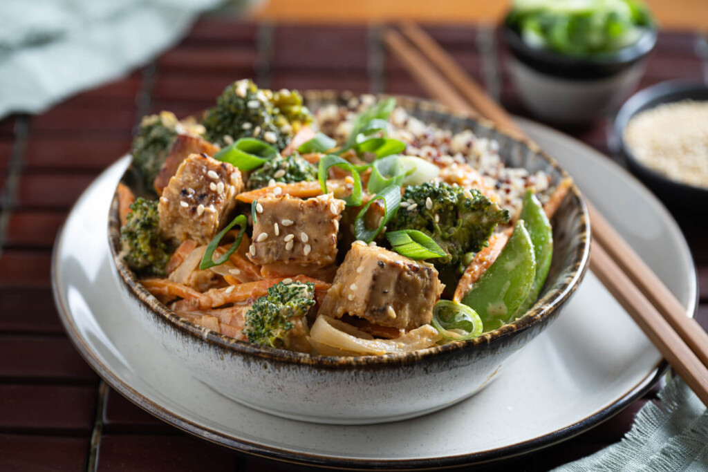 Bowl of tempeh stir fry with peanut ginger sauce and fresh vegetables as a wholesome healthy dinner recipe