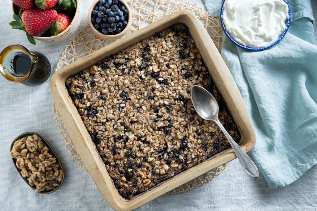 Overhead image of square pan with wild blueberry baked oatmeal with spoon