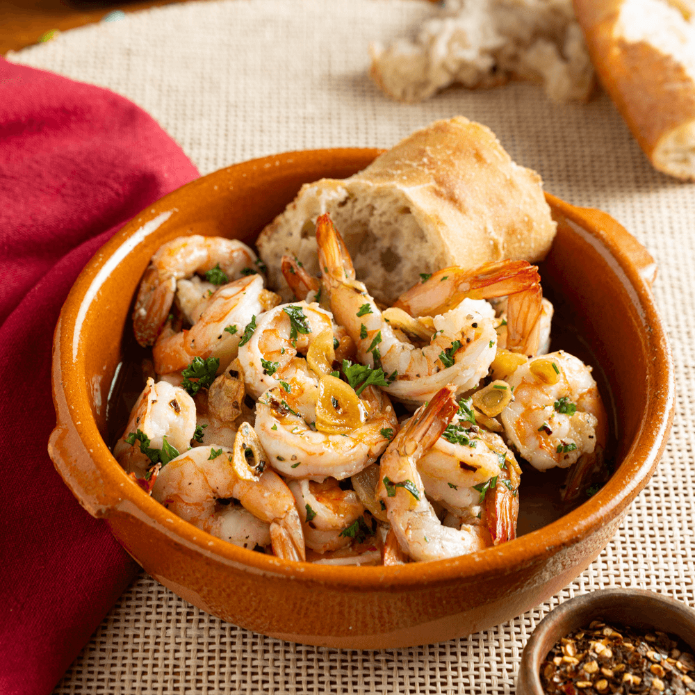 Terracotta bowl filled with spicy garlic shrimp for Spanish tapas