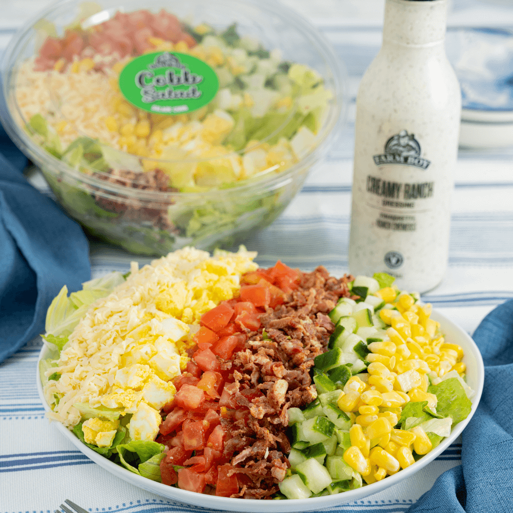 Bowl of Farm Boy Cobb Salad with bottle of Farm Boy Creamy ranch Dressing in background