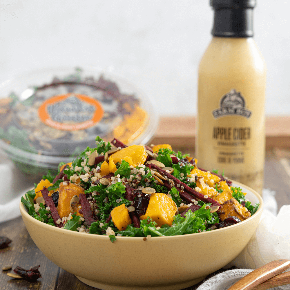 Bowl of Farm Boy Harvest Grain Salad with bottle of Farm Boy Apple Cider Vinaigrette in background