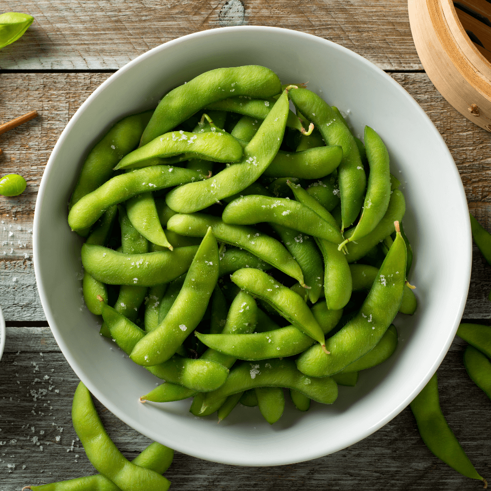 Overhead image of bowl of in-pod edamame sprinkled with salt