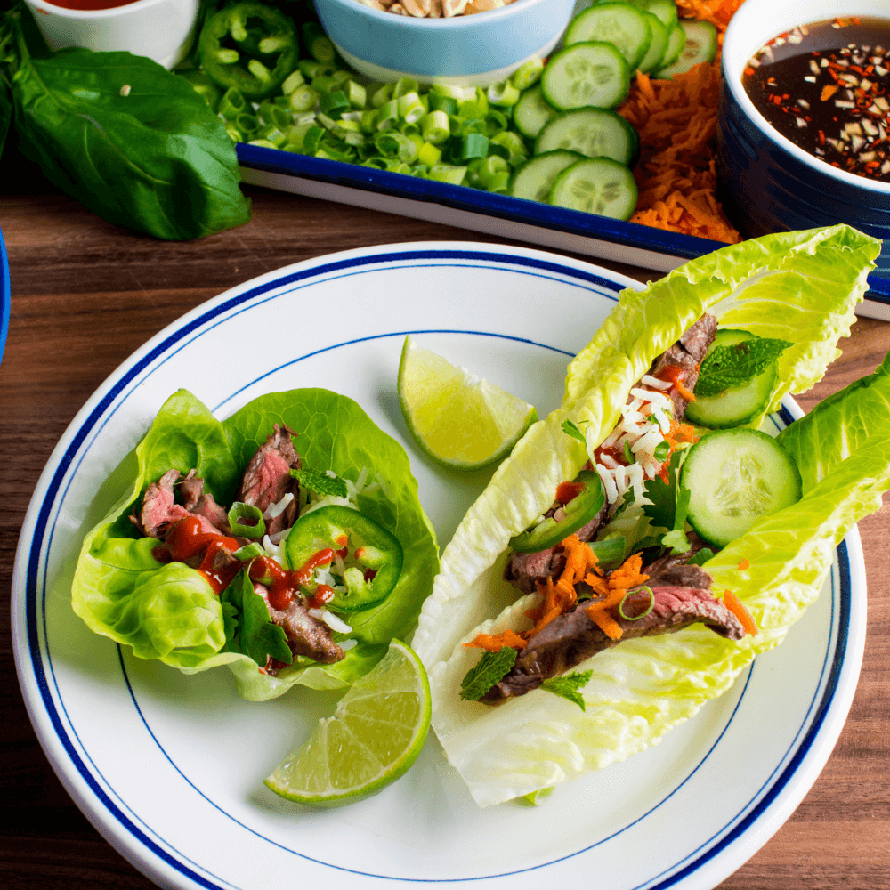 Plate with two lettuce wraps filled with vegetables and meat for Korean BBQ
