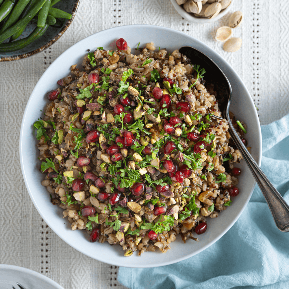 Overhead image of mixed grain pilaf garnished with fresh parsley and pomegranate arils
