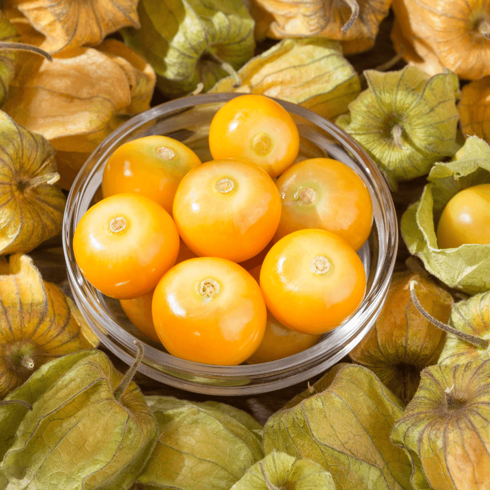 Small glass bowl of goldenberries on goldenberry husks