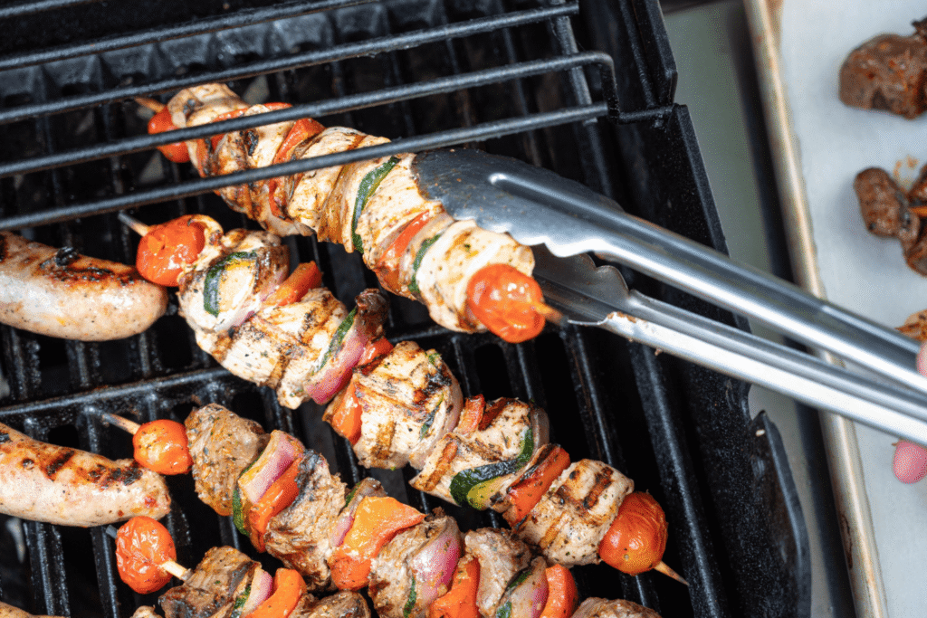 Overhead image of tongues flipping Farm Boy Kebabs on grill for Canada Day BBQ