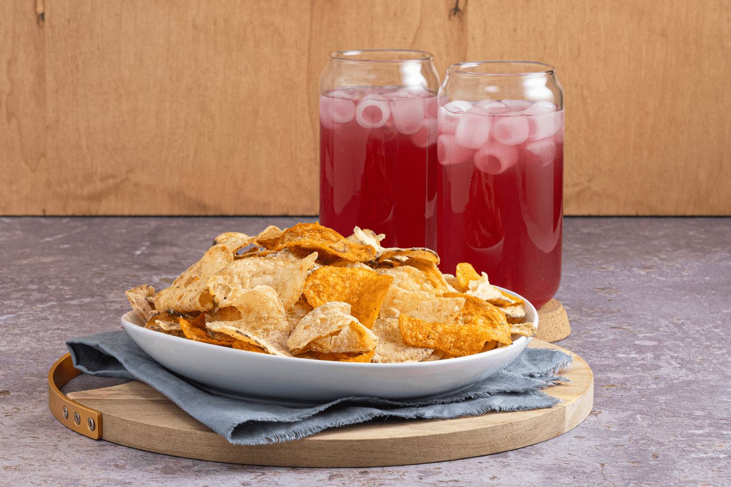 Plate of Farm Boy Long Weekend Chip Mix with two glasses of Farm Boy Watermelon Lime Fruit Drink in background