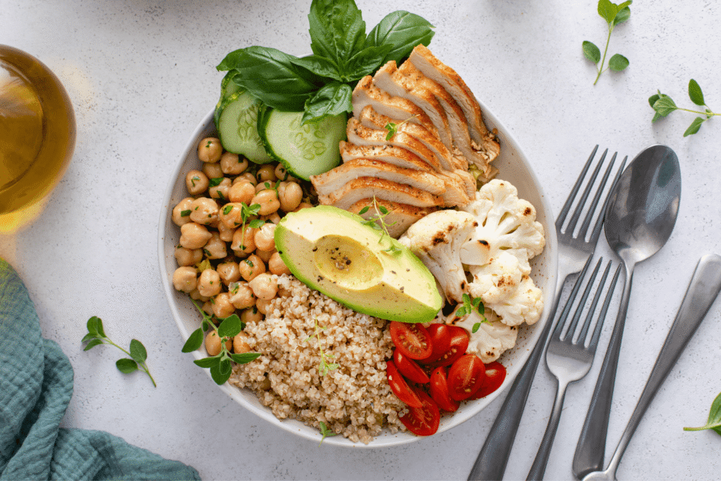Healthy high protein lunch bowl with grilled chicken, roasted cauliflower, herbed chickpeas and quinoa