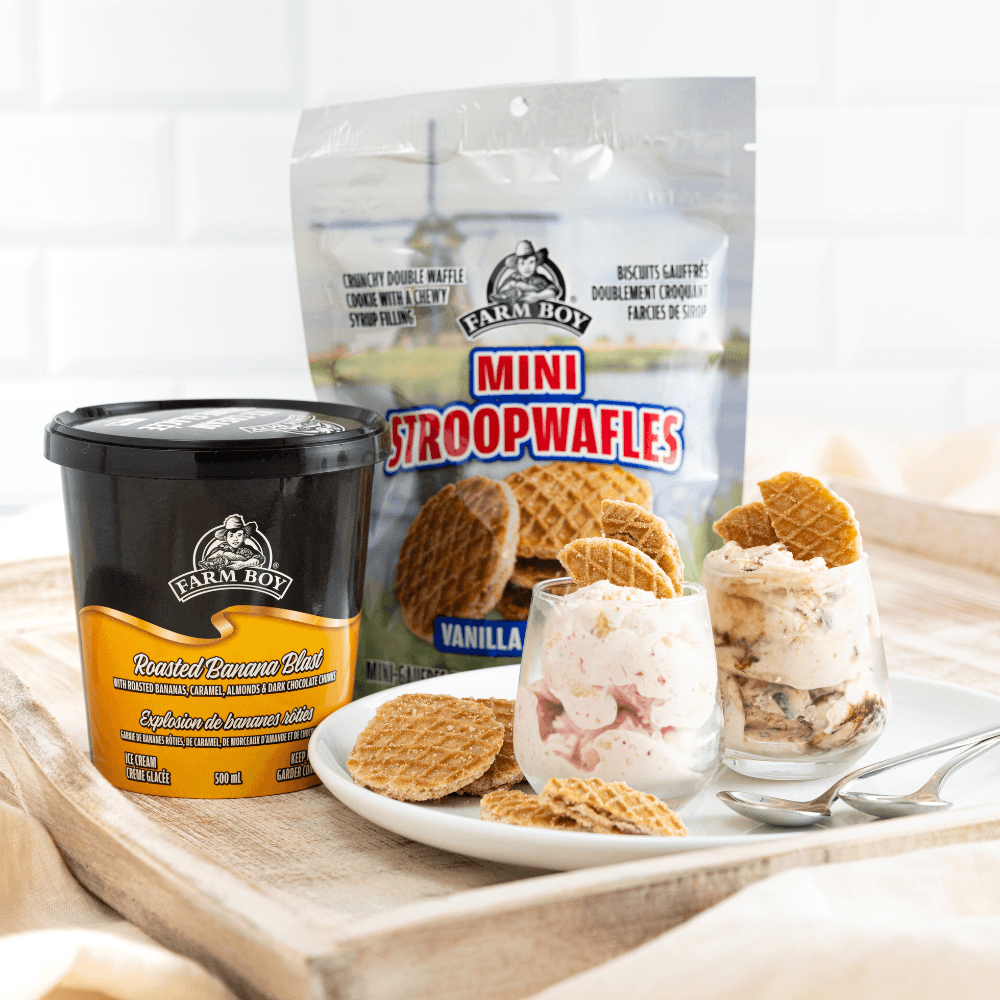 Two glasses with ice cream on plate with container of Farm Boy Roasted Banana Blast Ice Cream and bag of Farm Boy Mini Strropwafels