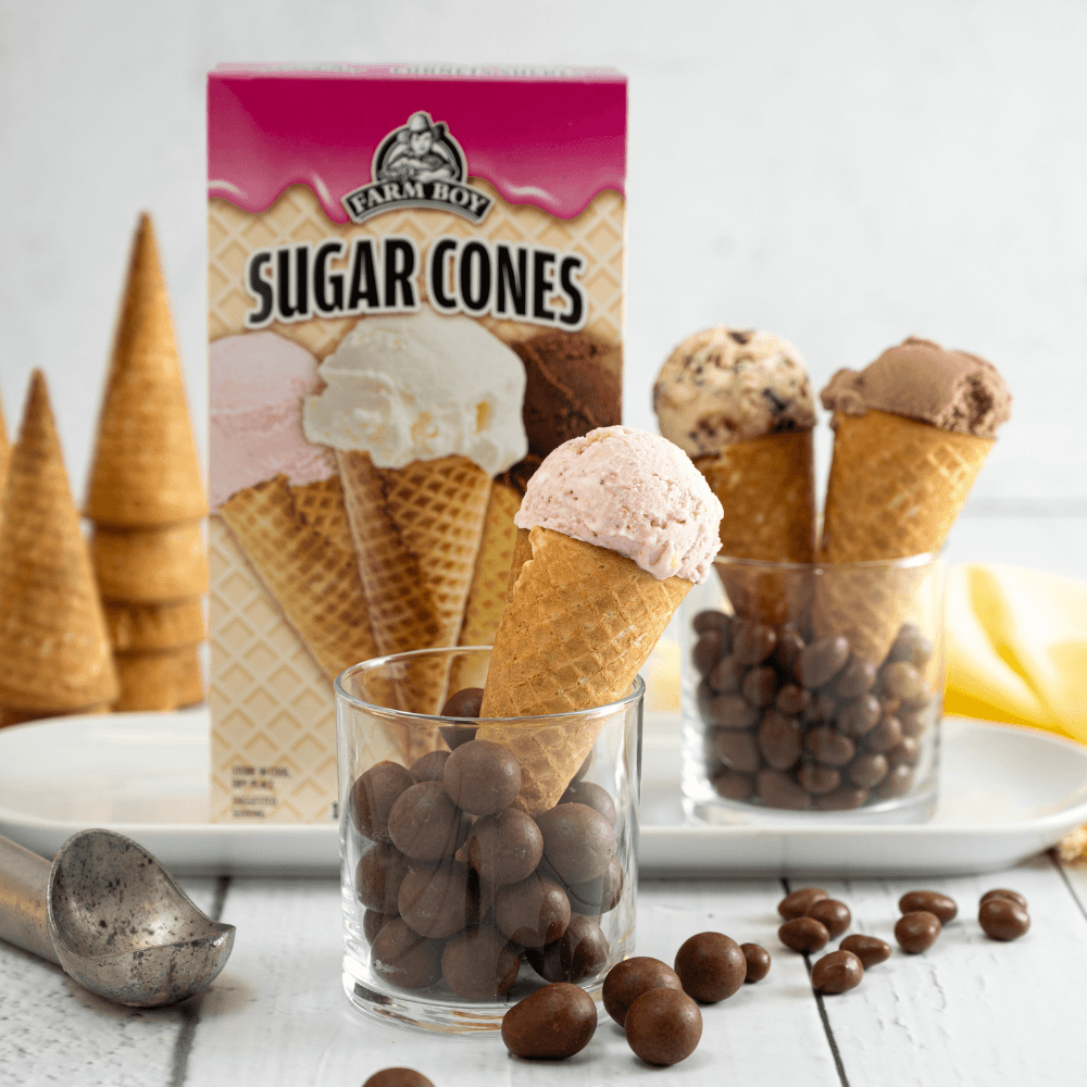 Multiple sugar cones with ice cream scoops in front of box of Farm Boy Sugar Cones
