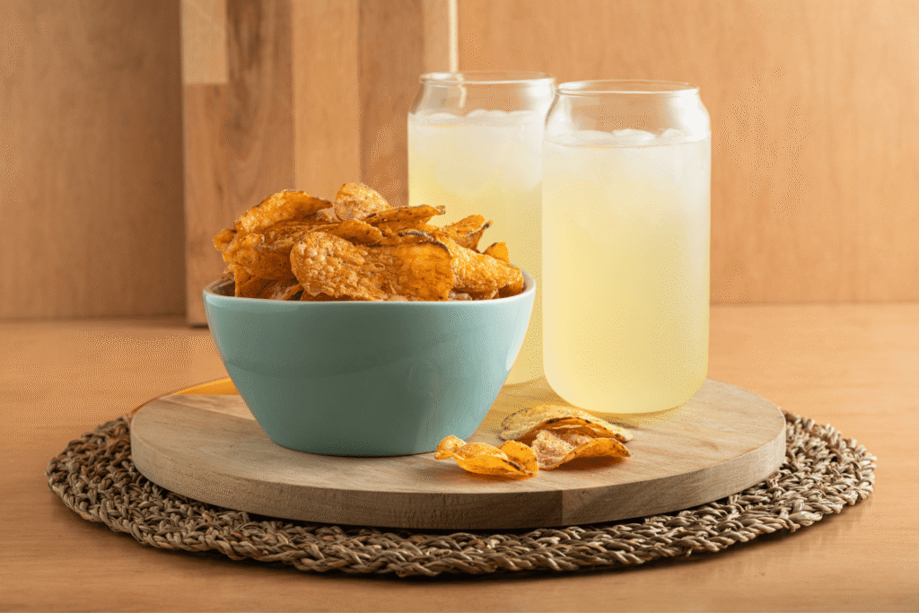Blue bowl of chips with two glasses of lemonade behind it