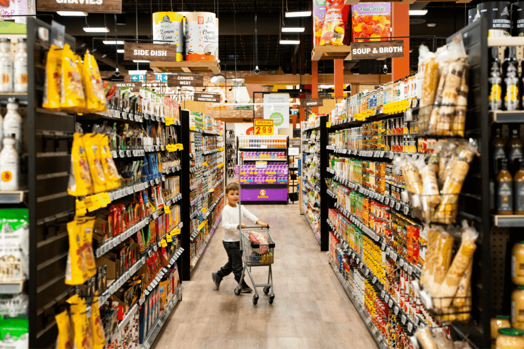 Young boy with child-sized cart in the aisles of a Farm Boy store