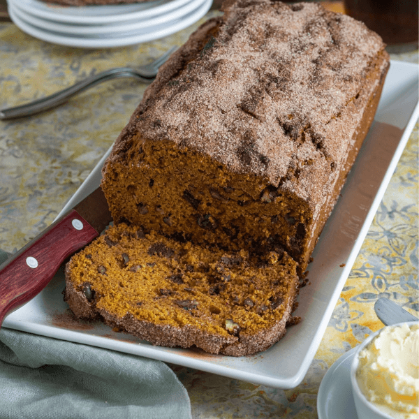 Angled top view of loaf of pumpkin bread with slice removed