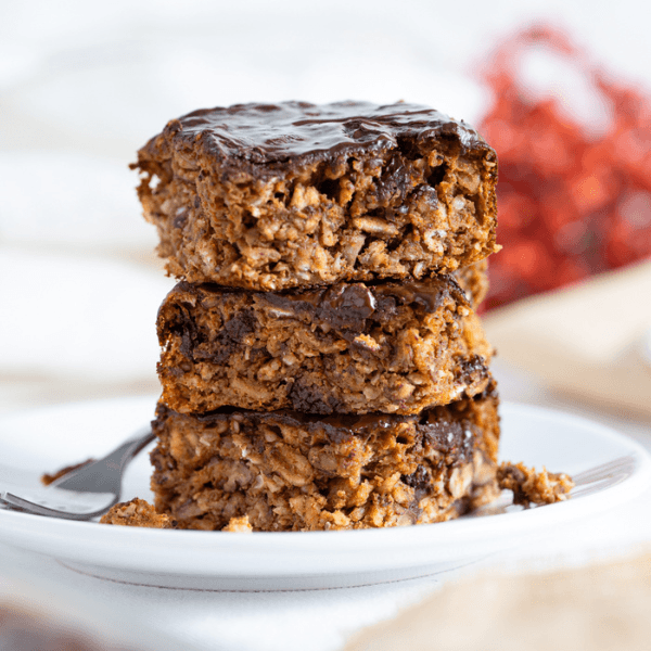 stack of three pumpkin pecan protein bars on a white plate
