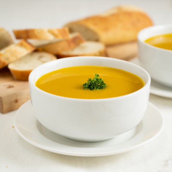 White bowl filled with soup garnished with fresh parsley